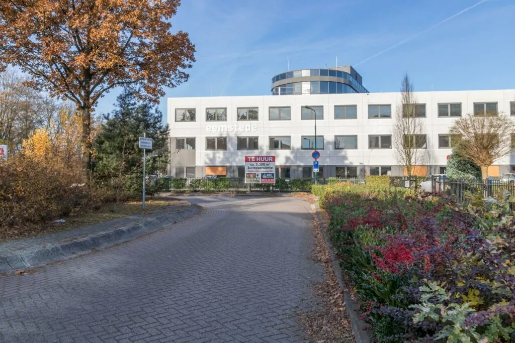 Kantoorpand Eemstede aan de Baarnsche Dijk met 'Te Huur'-bord in een herfstige omgeving.